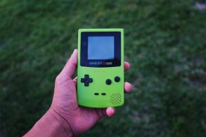 person holding a green Gameboy color console