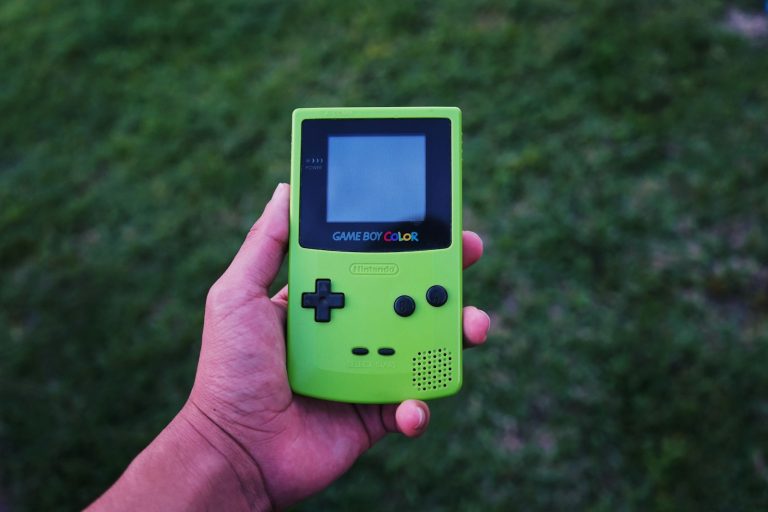 person holding a green Gameboy color console